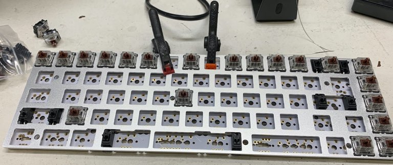 The plate clamped to the PCB, with some switches already
installed